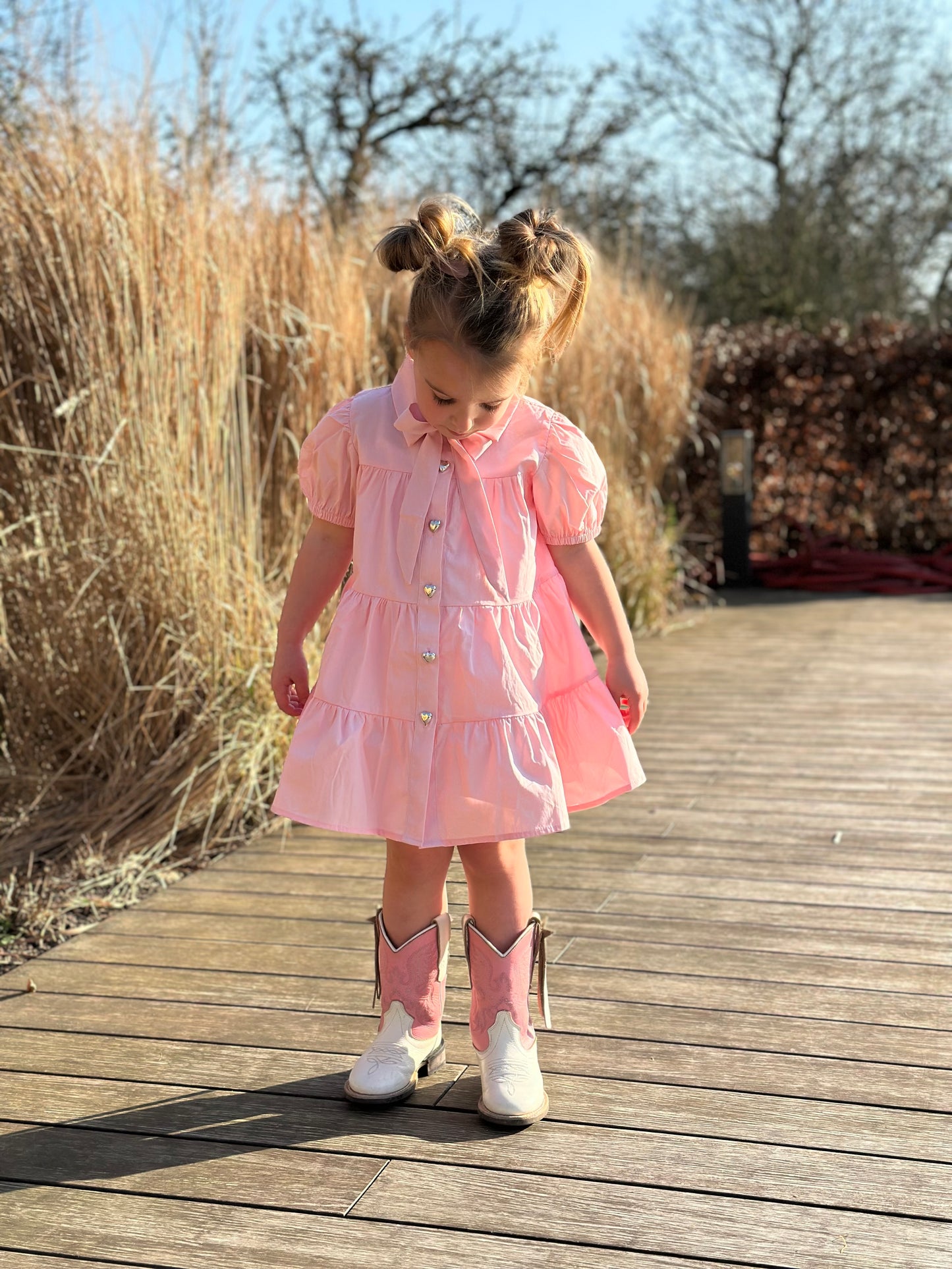 Roze katoenen jurk met pofmouw en strik